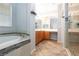 Bathroom featuring a soaking tub, glass shower, and dual vanity sinks at 10288 Grizzly Forest Dr, Las Vegas, NV 89178