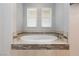 Bathroom showcasing a white jacuzzi tub surrounded by decorative tiles at 10288 Grizzly Forest Dr, Las Vegas, NV 89178