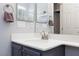 Bathroom with a vanity with gray cabinets, white countertop, and a large mirror with contemporary fixtures at 10288 Grizzly Forest Dr, Las Vegas, NV 89178