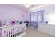 Cozy bedroom with white furniture, lilac walls, and a window with purple curtains at 10288 Grizzly Forest Dr, Las Vegas, NV 89178