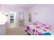 Charming bedroom with lilac walls, floral bedding, and access to a bathroom and closet at 10288 Grizzly Forest Dr, Las Vegas, NV 89178