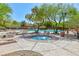 Relaxing community hot tub surrounded by lush greenery, lounge seating, and a view of the neighborhood pool at 10288 Grizzly Forest Dr, Las Vegas, NV 89178