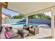 Relaxing covered patio with comfortable seating area overlooking the sparkling pool at 10288 Grizzly Forest Dr, Las Vegas, NV 89178