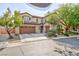 Charming two story home with a three car garage, desert landscaping and muted green shutters at 10288 Grizzly Forest Dr, Las Vegas, NV 89178
