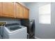 Convenient laundry room with modern washer, dryer, and wooden cabinets for ample storage at 10288 Grizzly Forest Dr, Las Vegas, NV 89178