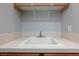 Functional laundry sink with tile backsplash and wooden frame, perfect for household tasks at 10288 Grizzly Forest Dr, Las Vegas, NV 89178