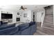 Open living room featuring fireplace, ceiling fan, wood floors, and stairwell to second floor at 10288 Grizzly Forest Dr, Las Vegas, NV 89178