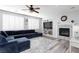 Comfortable living room with fireplace, ceiling fan, wood floors, and bright windows at 10288 Grizzly Forest Dr, Las Vegas, NV 89178