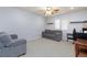 Neutral living room with gray sofas, desk setup, and bright natural light at 10288 Grizzly Forest Dr, Las Vegas, NV 89178