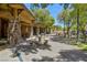 Community clubhouse patio with stone columns, outdoor seating and lush landscaping provides an inviting social space at 10288 Grizzly Forest Dr, Las Vegas, NV 89178