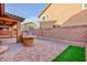 Spacious backyard featuring a built-in grilling area, block wall, artificial turf, and stylish pavers at 10956 Hunting Hawk Rd, Las Vegas, NV 89179