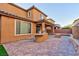 Paver stone backyard featuring a built-in grill, artificial turf, and block wall at 10956 Hunting Hawk Rd, Las Vegas, NV 89179