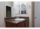 Bathroom vanity with dark cabinets, a sink, and a mirror, complemented by modern fixtures at 10956 Hunting Hawk Rd, Las Vegas, NV 89179