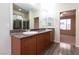 Bathroom featuring dual sinks, walk-in shower and a doorway to another room at 10956 Hunting Hawk Rd, Las Vegas, NV 89179
