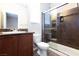 Bathroom featuring a vanity sink, toilet, and tiled shower at 10956 Hunting Hawk Rd, Las Vegas, NV 89179