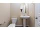 Bright half bathroom with white fixtures and wood-look floors at 10956 Hunting Hawk Rd, Las Vegas, NV 89179