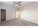 Neutral bedroom with soft carpet, a ceiling fan, and a doorway leading to a walk-in closet at 10956 Hunting Hawk Rd, Las Vegas, NV 89179