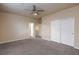 Spacious bedroom featuring plush carpet, ceiling fan, and a closet with sliding doors at 10956 Hunting Hawk Rd, Las Vegas, NV 89179