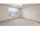 Spacious bedroom features neutral carpet, a ceiling fan, and a large window at 10956 Hunting Hawk Rd, Las Vegas, NV 89179