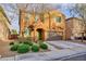 Charming two-story home boasts a well-manicured front yard with vibrant green bushes and neutral exterior at 10956 Hunting Hawk Rd, Las Vegas, NV 89179