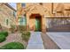 Inviting front entrance with a green door, well-maintained landscaping, and a convenient two-car garage at 10956 Hunting Hawk Rd, Las Vegas, NV 89179