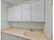 Bright laundry room with white cabinets and a large utility sink at 1401 Via Savona Dr, Henderson, NV 89052