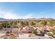 Overhead view of a charming two-story home with a three-car garage, desert landscaping, and mountain views at 1634 Georgia Ave, Boulder City, NV 89005