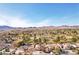 Scenic aerial view of a charming home with mountain views, desert landscaping, and a nearby golf course at 1634 Georgia Ave, Boulder City, NV 89005