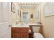 Well-lit half bathroom with a single wooden vanity and a large mirror at 1634 Georgia Ave, Boulder City, NV 89005
