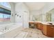 Bright bathroom with a large tub, vanity, makeup area, tile floors and a large arched window at 1634 Georgia Ave, Boulder City, NV 89005