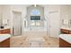 Main bathroom featuring a large soaking tub beneath a bright, arched window and a walk-in shower at 1634 Georgia Ave, Boulder City, NV 89005