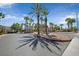 Gated entrance to a community featuring palm trees, desert landscaping, and security at 1830 N Buffalo Dr # 1029, Las Vegas, NV 89128