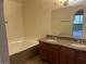 A bright bathroom features double sinks, granite counters and tub with shower at 1842 N Decatur Blvd # 101, Las Vegas, NV 89108