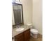 Bathroom with granite countertop, bronze faucet, framed mirror, and white toilet at 1842 N Decatur Blvd # 101, Las Vegas, NV 89108