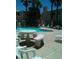 A view of the pool area with a stone table, lounge chairs, waterfall, and palm trees at 1851 Hillpointe Rd # 2112, Henderson, NV 89074