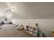 Finished attic with a window, carpet, angled ceiling, and simple shelving in the corner at 1951 Jim Haworth Ct, Logandale, NV 89021