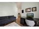 Cozy living area features a dark sofa, wood-look floors, and a sleek desk with wall art at 1951 Jim Haworth Ct, Logandale, NV 89021