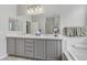Elegant bathroom with double sinks, gray vanities, and a soaking tub, offering a relaxing retreat at 2140 Idaho Falls Dr, Henderson, NV 89044