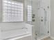 Bathroom featuring a soaking tub, a glass-enclosed shower with tiled floors and a large, bright window at 2140 Idaho Falls Dr, Henderson, NV 89044