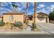 Inviting front exterior with a well-manicured lawn, palm trees and driveway at 2140 Idaho Falls Dr, Henderson, NV 89044