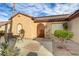 Exterior view of the property with a courtyard, a stone walkway, desert landscaping, and a wooden front door at 2140 Idaho Falls Dr, Henderson, NV 89044