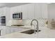 Bright kitchen with white cabinets, stainless steel appliances, and elegant quartz countertops with stylish backsplash at 2140 Idaho Falls Dr, Henderson, NV 89044