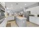 Bright kitchen boasts white cabinets, stainless appliances, and a center island with marble countertop at 2140 Idaho Falls Dr, Henderson, NV 89044