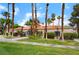 Charming single-story home showcasing a tiled roof, manicured lawn, and mature palm trees, exuding curb appeal at 221 Mission Catalina Ln # 202, Las Vegas, NV 89107