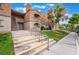 A multi-story condo building featuring a well-maintained lawn, landscaping, and a sidewalk for access at 221 Mission Catalina Ln # 202, Las Vegas, NV 89107