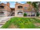 Inviting multi-story condo building featuring a well-maintained lawn and charming architectural details at 221 Mission Catalina Ln # 202, Las Vegas, NV 89107