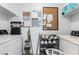 Functional laundry room with washer, dryer, shelving, and storage options for cleaning supplies at 221 Mission Catalina Ln # 202, Las Vegas, NV 89107