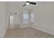Bright bedroom with a fan, mirrored closet, window, and wood-look flooring at 239 Highgate St, Henderson, NV 89074