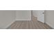 Hallway featuring neutral walls and baseboards, white doors, and modern wood-look floors at 239 Highgate St, Henderson, NV 89074