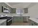 Updated kitchen features stainless steel appliances, sage cabinets, and a bright window at 239 Highgate St, Henderson, NV 89074